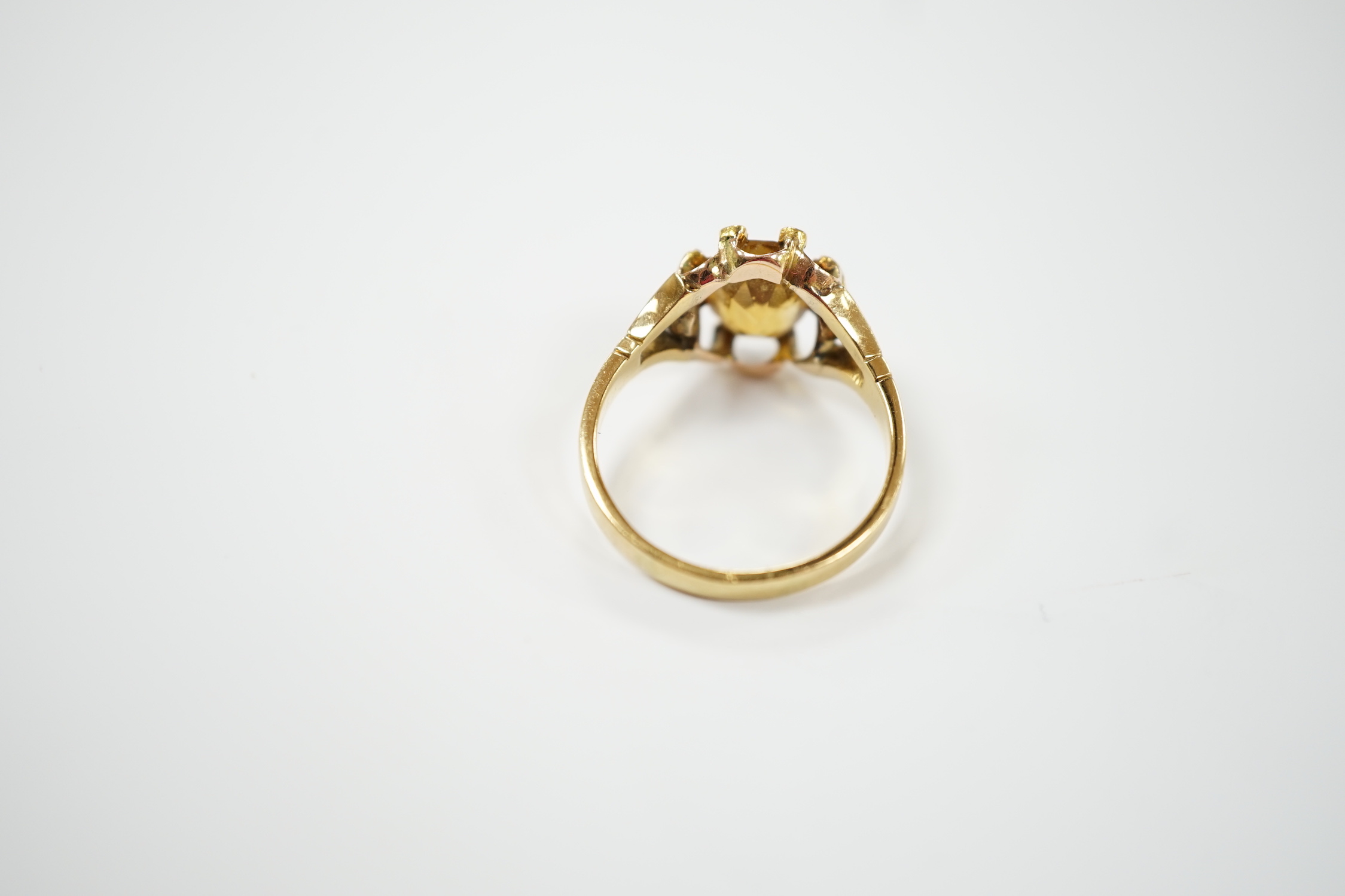 An 18ct and single stone oval cut citrine set dress ring, with eight stone diamond chip set border, size V